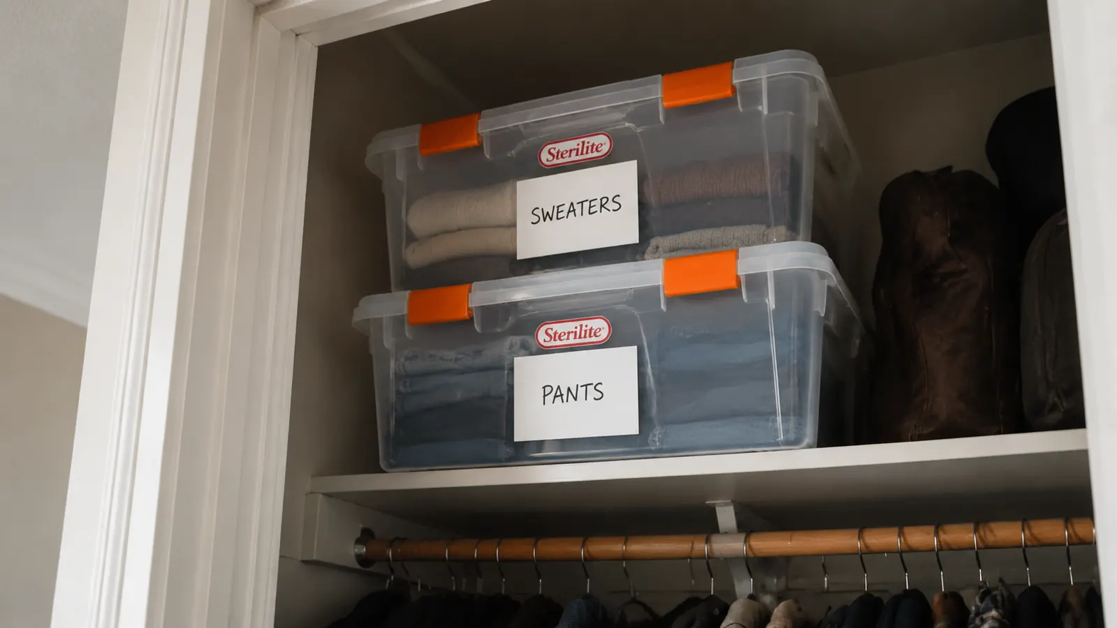 Clear stackable bins being stacked two high in a closet with the latching lids clipped shut