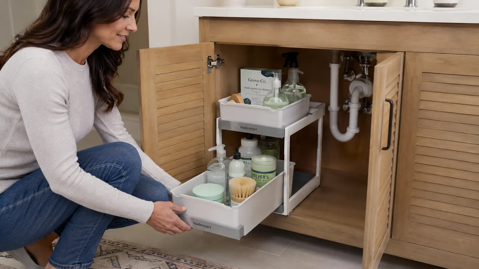 Close-up of the madesmart organizer pipe cutout straddling a standard vertical drain pipe